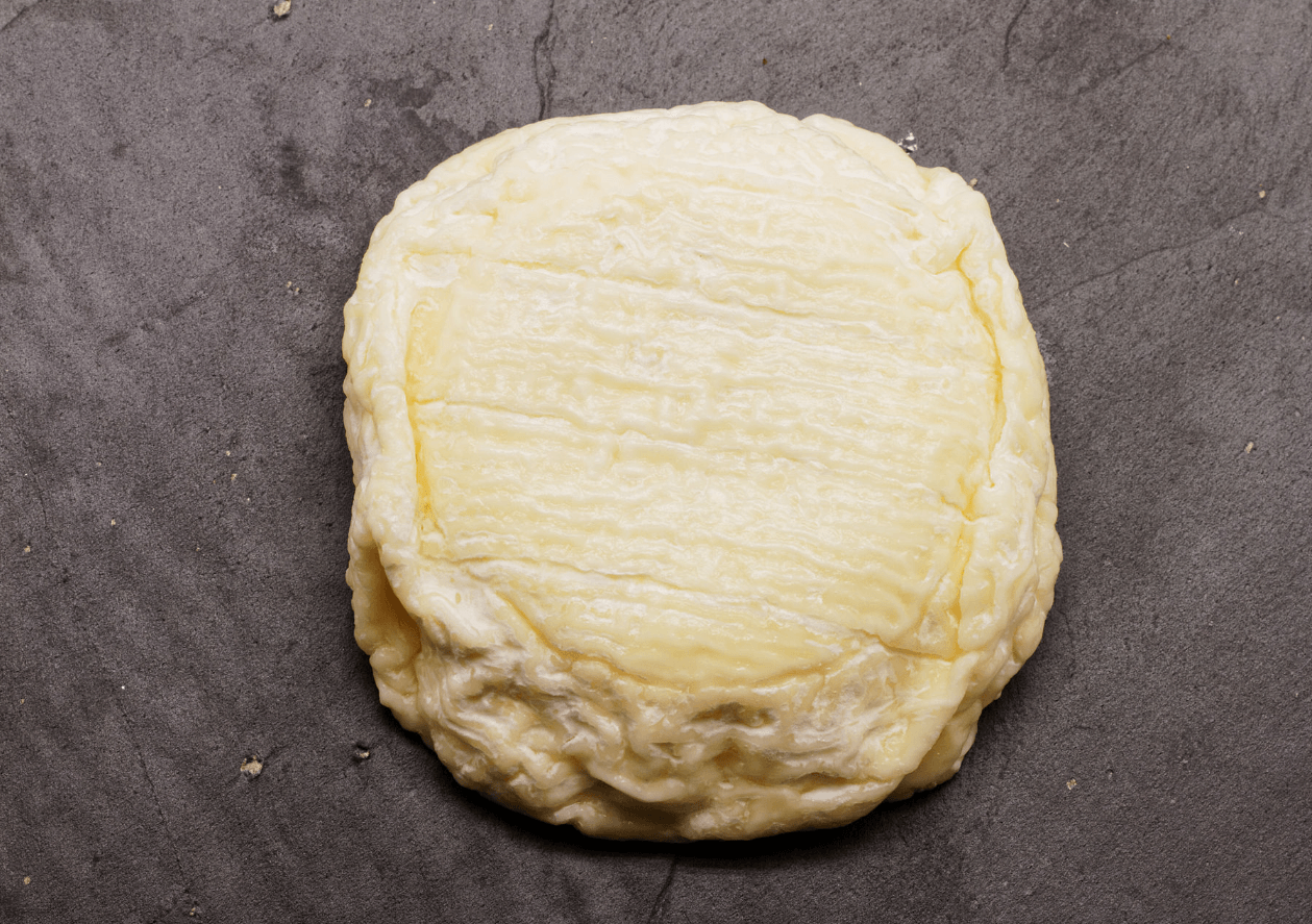 Un pot de miel de Paris avec une cuillère en bois plongeant dans le miel, créant un filet de miel entre le pot et la cuillère.